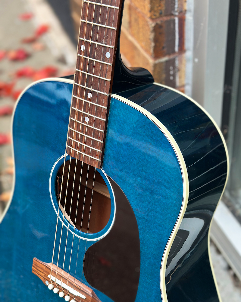 Blue acoustic guitar with a blurred background