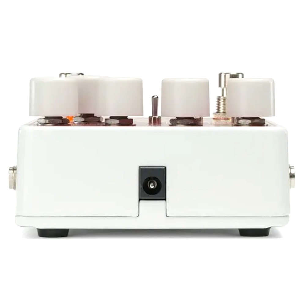 White guitar effects pedal with multiple knobs on a white background
