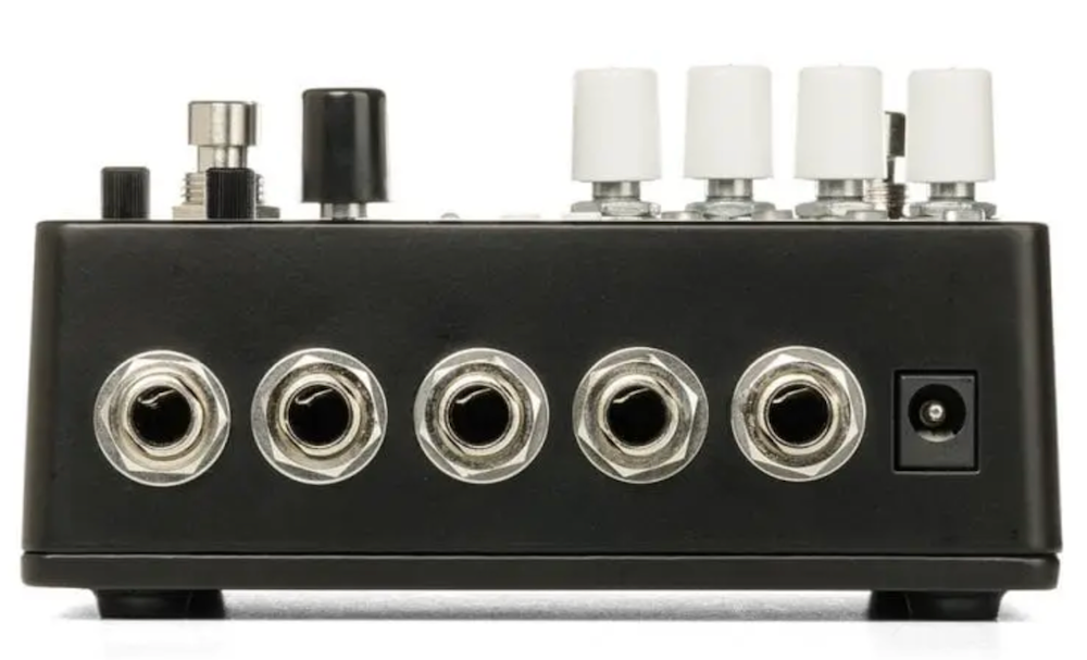Guitar effects pedal with multiple jacks on a white background