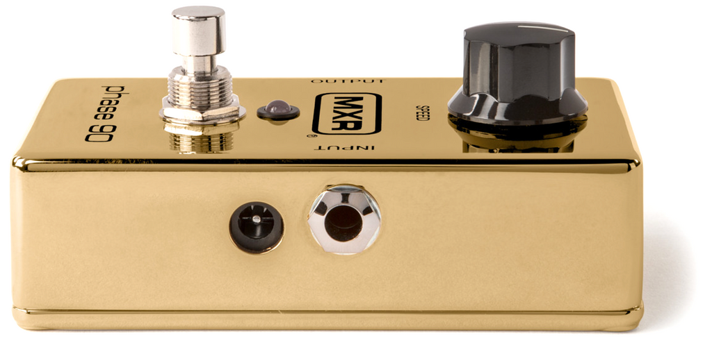 Gold guitar effects pedal with knobs and switches on a white background