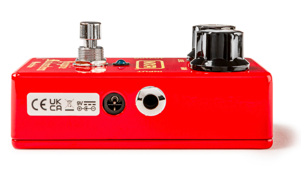 Red guitar effects pedal with various connectors on a white background